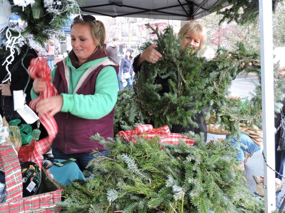 Mackenzey Shatto prepares bows for the wreaths purchased by Laurie Samuelson, of Bloomington, during the 2018 Holiday Market. This year's market will include carriage rides as well as arts and crafts and farm products being sold at the Showers Common area.