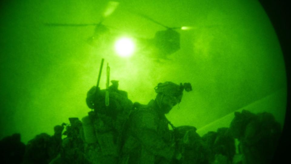 Soldiers take cover from the icy propeller wash of a CH-47 Chinook helicopter at the Yukon Training Area in Alaska on April 3, 2023, as they prepare to air assault an objective during a training exercise. (Benjamin Wilson/Army)