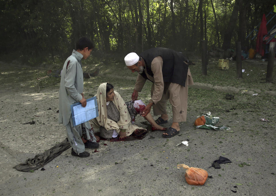 <p>A wounded woman is helped at the site of double explosions, in Kabul, Afghanistan, April 30, 2018. (Photo: Massoud Hossaini/AP) </p>