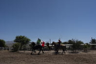 Horse trainer Alejandro Luna works at Rancho El Refugio date palm ranch in Twentynine Palms, Calif., Tuesday, June 11, 2024. (AP Photo/Jae C. Hong)