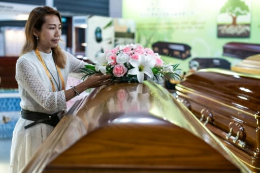 An exhibitor arranges flower on a casket during the Asia Funeral and Cemetery Expo in Hong Kong on May 14, 2019