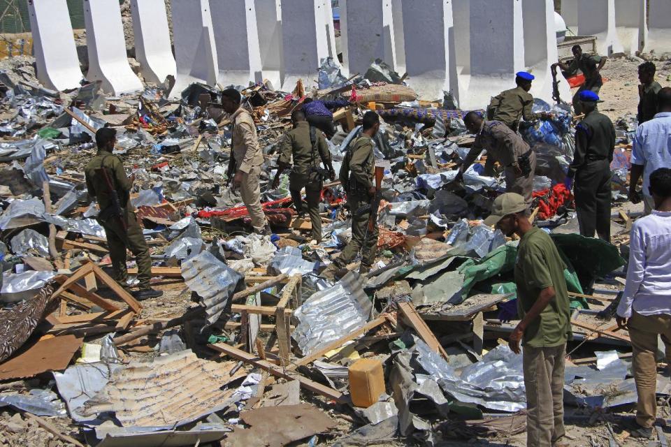 Somali soldiers filter through the debris of a destroyed building near the scene of a suicide car bomb attack in Mogadishu, Somalia, Monday, Jan, 2, 2017. A suicide bomber detonated an explosives-laden vehicle at a security checkpoint near Mogadishu's international airport Monday, killing at least three people, a Somali police officer said. (AP Photo/Farah Abdi Warsameh)