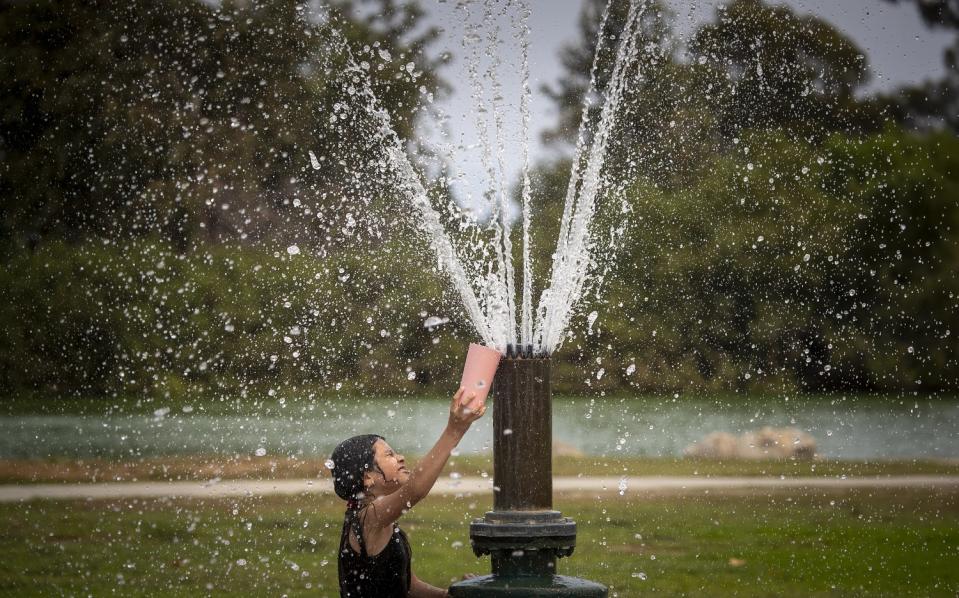 Laura Martinez, 8, cools off in a spray pool at Mile Square Park.