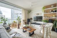 The brief for a simple and light home was executed via a neutral palette with plenty of natural textures. The living room features wicker and live-edge wood furniture, a cork-finished wallpaper along the media wall with chunky-weaves and plush soft furnishings. Plants add a layer of freshness to the composition.