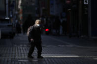 A woman wearing a face mask as a precaution against the coronavirus, walks in downtown Seoul, South Korea, Wednesday, Jan. 27, 2021. (AP Photo/Lee Jin-man)