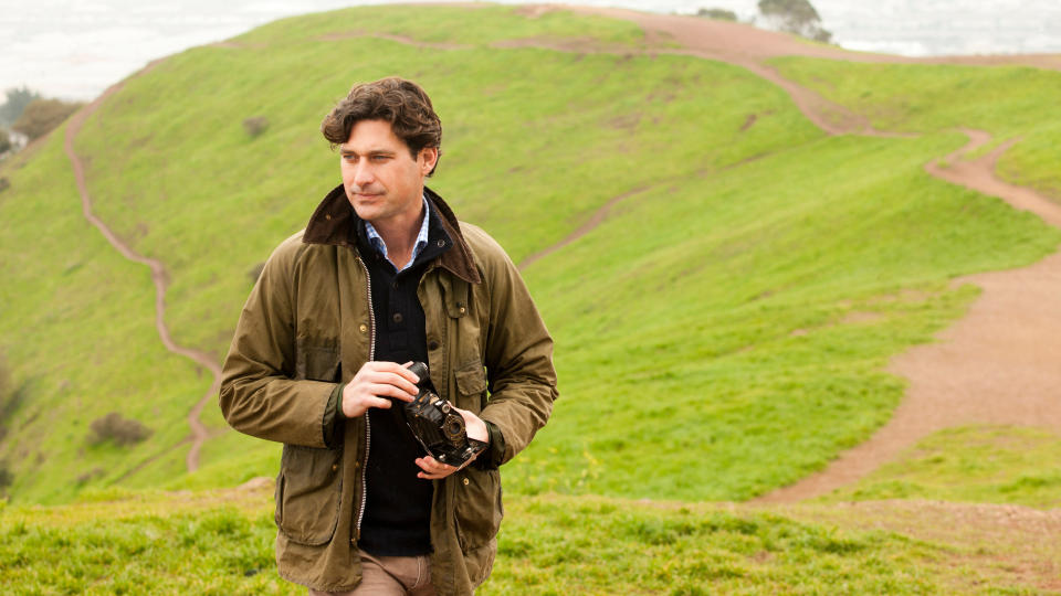 man holding vintage camera in countryside