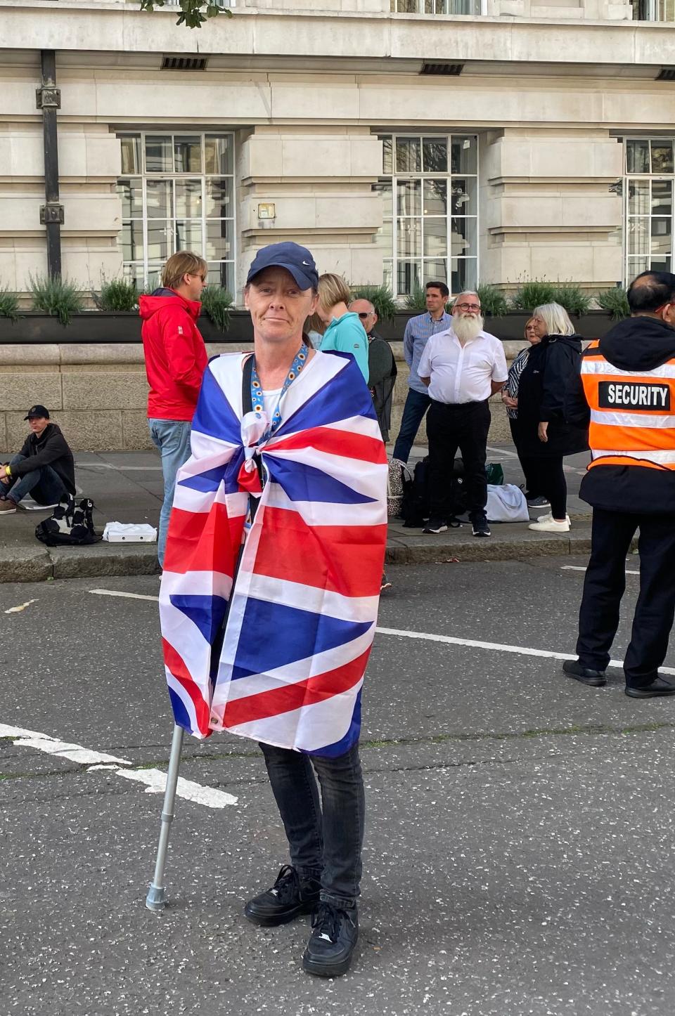 A woman wrapped in the Union Jack queued to pay their respects as Queen Elizabeth II lies in state.