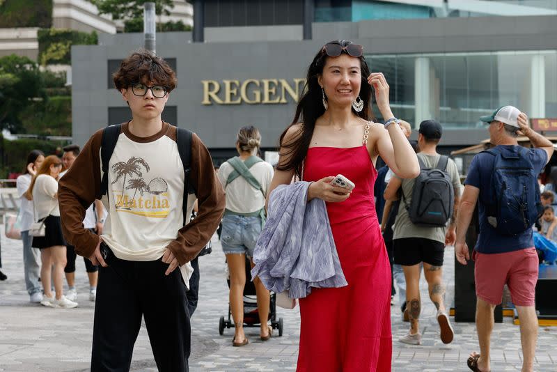 Laura Li, 28, and her cousin Diego Deng, 20, walk as they search for guides for photography on the Chinese social media platform Xiaohongshu, a day ahead of the Chinese Labour Day 'Golden Week' holidays, in Hong Kong