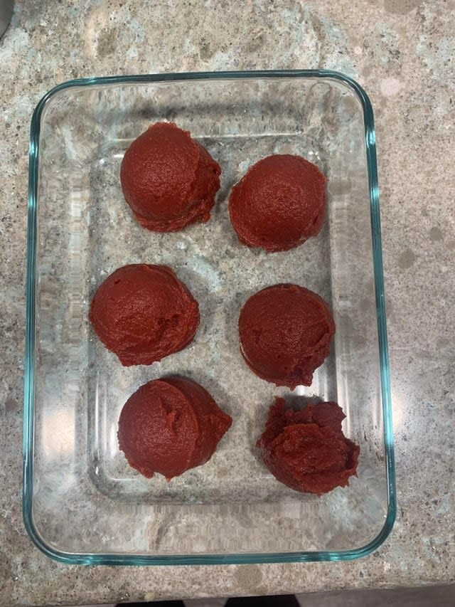 Scoops of tomato paste in a baking dish.