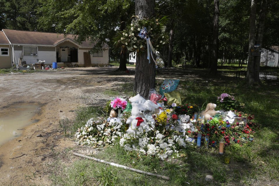 Memorial flowers, balloons and wreaths lie under a tree in the front yard of the home outside of Cleveland, Texas, on Tuesday, May 16, 2023, where five people including a young boy, were killed in April 2023. In 2022, deputies did not arrest Francisco Oropeza, who is accused of this mass shooting, after he was reported for domestic violence and never contacted federal authorities to check his immigration status, although immigration officials say he was in the country illegally. (AP Photo/Michael Wyke)