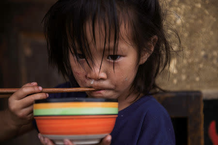 A girl eats her meal in a mountain village on an unnamed tributary of the fierce and flood-prone Dadu river near Leshan in Sichuan province, China, August 3, 2018. REUTERS/Damir Sagolj
