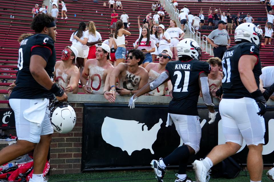 The Cincinnati Bearcats high five fans in the student section after the second half of the NCAA football game between the Cincinnati Bearcats and the Eastern Kentucky Colonels at Nippert Stadium in Cincinnati on Saturday, Sept. 2, 2023. Cincinnati Bearcats won 66-13.