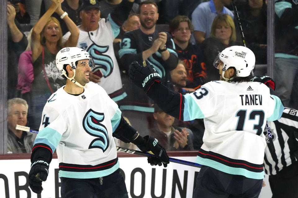 Seattle Kraken defenseman Justin Schultz (4) smiles as he celebrates after his goal against the Arizona Coyotes with left wing Brandon Tanev (13) during the second period of an NHL hockey game Monday, April 10, 2023, in Tempe, Ariz. (AP Photo/Ross D. Franklin)