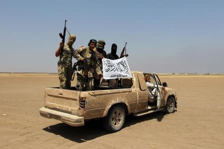 Fighters of the Syrian Islamist rebel group Jabhat Fateh al-Sham cheer on a pick truck after a Russian helicopter had been shot down in the north of Syria's rebel-held Idlib province, Syria August 1, 2016. REUTERS/Ammar Abdullah