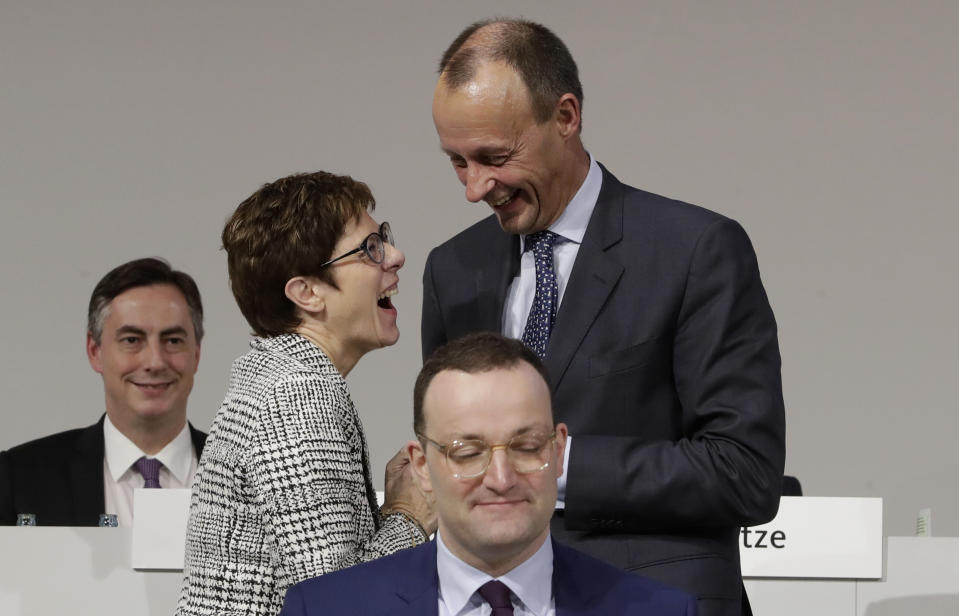 CDU general secretary Annegret Kramp-Karrenbauer, left, and Friedrich Merz share a light moment behind German Health Minister Jens Spahn at the party convention of the Christian Democratic Party CDU in Hamburg, Germany, Friday, Dec. 7, 2018. 1001 delegates are electing a successor of German Chancellor Angela Merkel who doesn't run again for party chairmanship after more than 18 years at the helm of the party. (AP Photo/Michael Sohn)