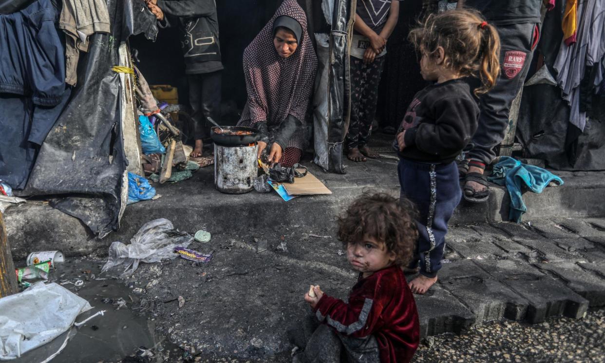 <span>Palestinian families displaced from their homes make preparations for the iftar dinner in temporary tents in Rafah on Thursday.</span><span>Photograph: Anadolu/Getty Images</span>