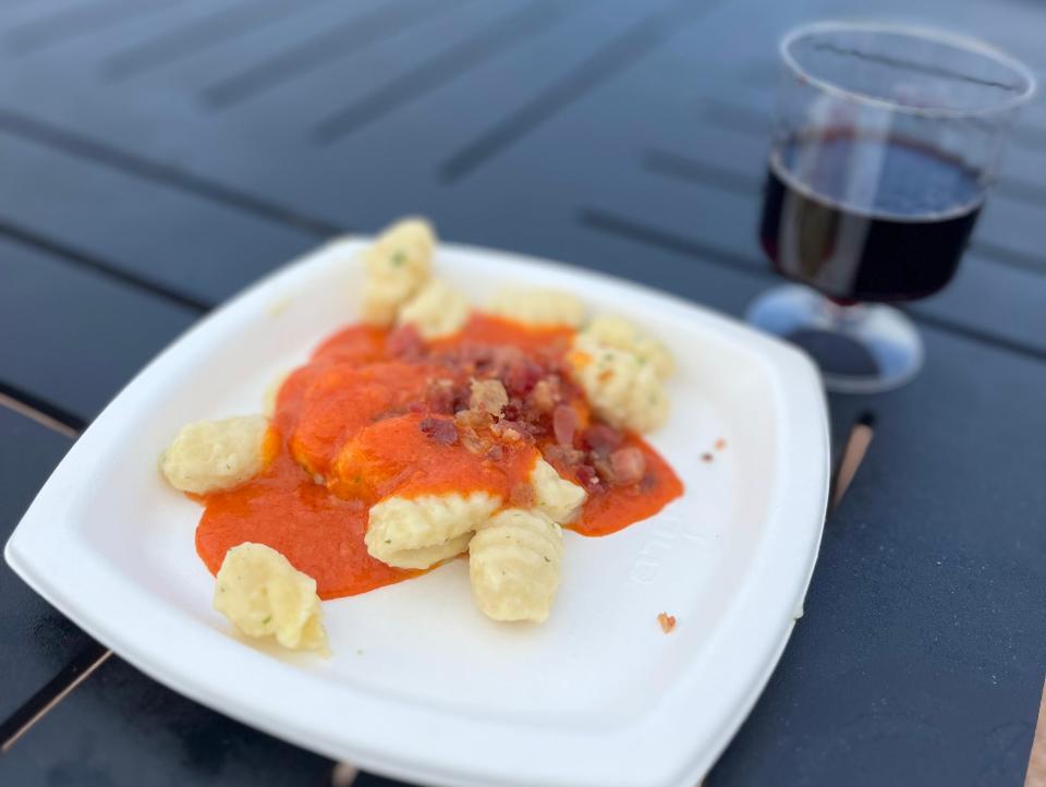 small plate of gnocchi and glass of red wine from the italy pavilion at epcot in disney world