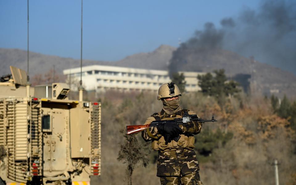 An Afghan security personnel stands guard as smoke billows from the Intercontinental Hotel during a fight between gunmen and Afghan security forces in Kabul on January 21, 2018 - WAKIL KOHSAR/AFP