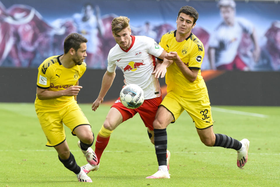 Dortmund's Raphael Guerreiro, left, Leipzig's Timo Werner, center, and Dortmund's Giovanni Reyna fight for the ball during the German Bundesliga soccer match between RB Leipzig and Borussia Dortmund in Leipzig, Germany, Saturday, June 20, 2020. (AP Photo/Jens Meyer, Pool)