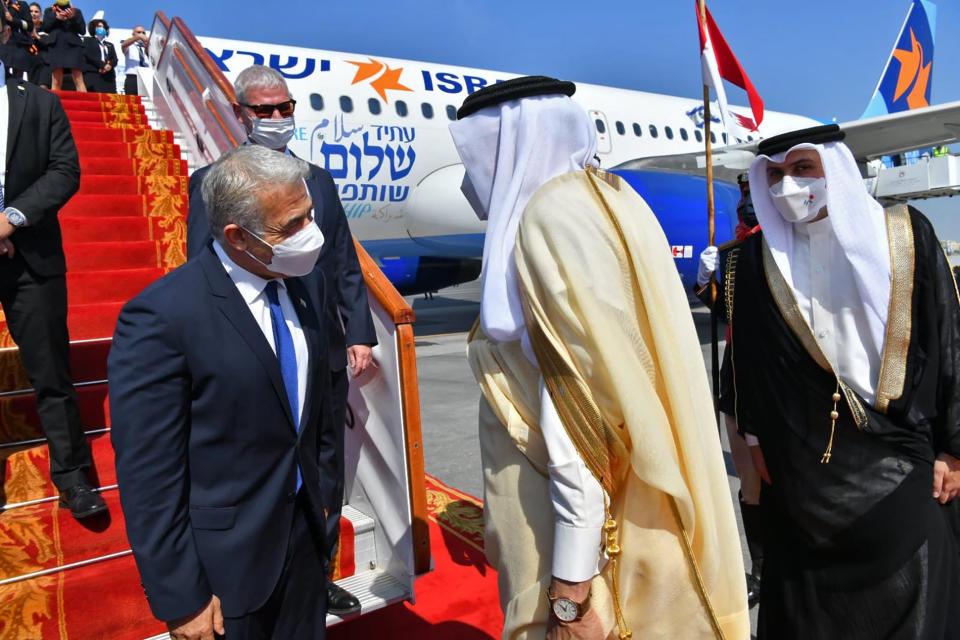 Israel's Foreign Minister Yair Lapid, center left, is met by his Bahraini counterpart, Abdullatif bin Rashid Alzayani, center right, for the first high-level visit to the small Gulf state by a senior Israeli official since the signing of a landmark agreement to establish diplomatic ties between the two countries last year, in Manama, Bahrain, Thursday, Sept. 30, 2021. Lapid will inaugurate Israel’s embassy. (Shlomi Amshalem/GPO via AP)