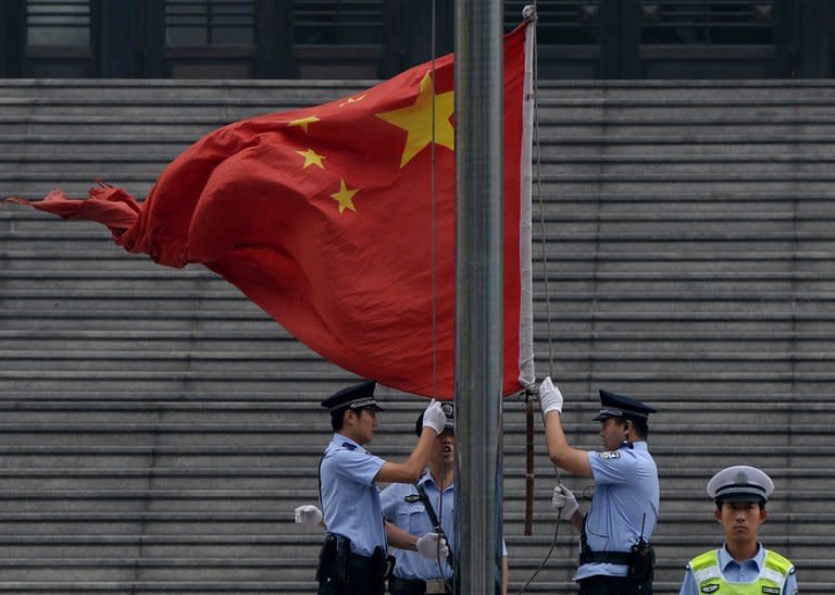 Police raise the Chinese flag outside the Intermediate People's Court in Jinan, Shandong Province, on September 22, 2013. The court has sentenced former leading politician Bo Xilai to life in prison after a sensational corruption trial that exposed intrigue and lavish lifestyles in the higher levels of the ruling party