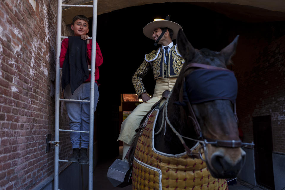 A child watches a bullfight next to a picador, a horse mounted bullfighter assistant, at Las Ventas bullring in Madrid, Spain, Sunday, March 26, 2023. Those aged over 75 were the least likely to attend. While bullfighting is nowhere close to drawing the crowds of half a century ago, it remains an important, if divisive, symbol of Spanish identity in the country's south and central regions. (AP Photo/Manu Fernandez)
