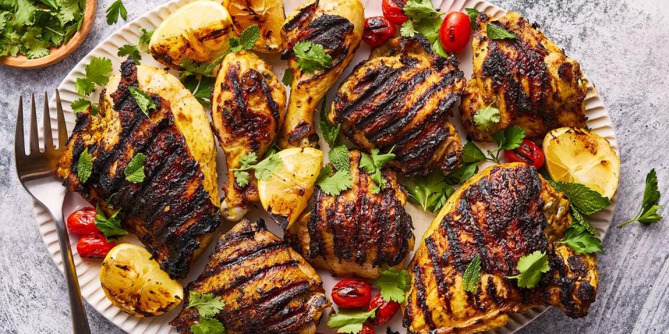 grilled chicken with grilled lemon wedges, tomatoes topped with parsley and mint