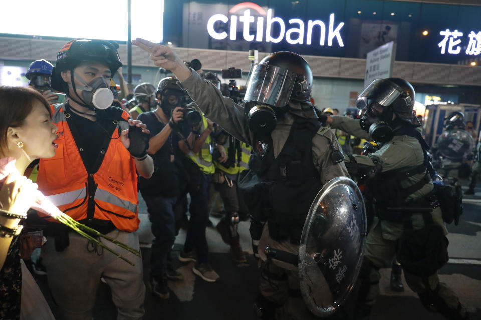 Police disperse members of the media in Hong Kong, Sunday, Oct. 20, 2019. Hong Kong protesters again flooded streets on Sunday, ignoring a police ban on the rally and setting up barricades amid tear gas and firebombs. (AP Photo/Mark Schiefelbein)