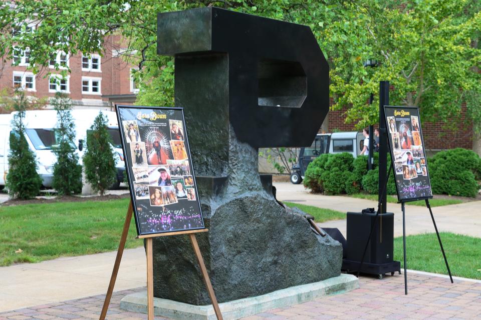 Memorial pictures sit at the Unfinished P statue at a vigil in remembrance for Sara Brown on Tuesday, Aug. 29 2023, at Purdue University in West Lafayette, Ind. Brown, a Purdue graduate student, was killed Aug. 24, 2023, in a vehicle accident.