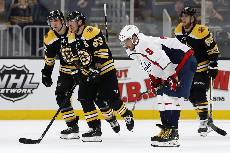 Washington Capitals' Alex Ovechkin bends over as Boston Bruins' Brad Marchand (63) leads teammates David Pastrnak (88) and Patrice Bergeron to the bench after a goal during the first period of an NHL hockey game Monday, Dec. 23, 2019, in Boston. (AP Photo/Winslow Townson)