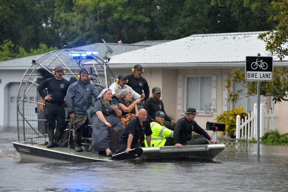 An airboat carrying evacuees from the Pinecraft neighborhood of Sarasota approaches dry land on August 5. Multiple law enforcement and emergency services have conducted evacuations in the area following Tropical Storm Debby