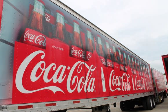 Semi tractor-trailer with bottles of Coca-Cola painted on side.