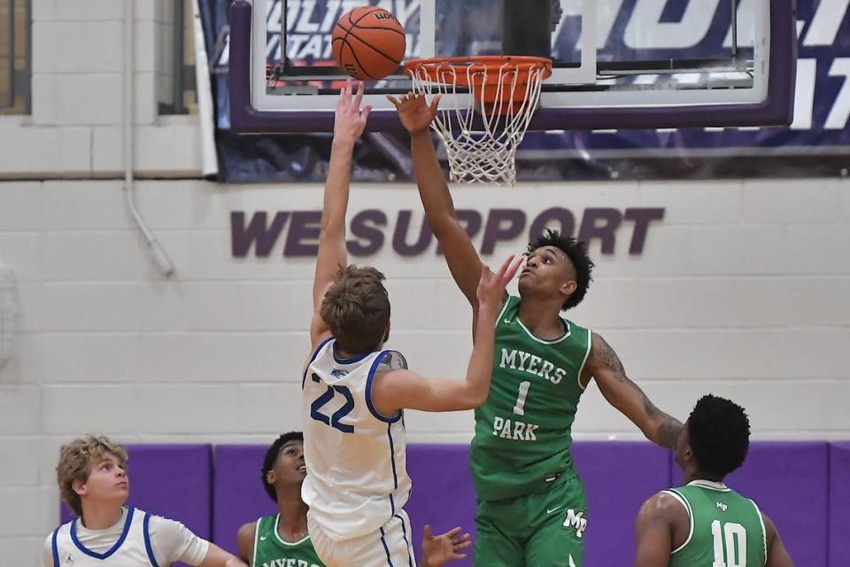 Myers Park’s Sadiq White Jr. (1) stretches to block the shot from Garner’s Keaton Bloms (22) during the first half. The Myers Park Mustangs and the Garner Trojans met in the John Wall Holiday Invitational in Raleigh, N.C. on December 27, 2023.