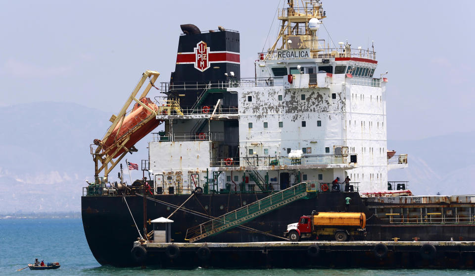 In this April 16, 2019 photo, a ship fills up on fuel from a tanker truck on the Thor terminal in Carrefour, a district of Port-au-Prince Haiti. Through the Venezuelan aid program known as Petrocaribe, more than half the costs of the oil given to Haiti, which came at a heavily discounted price, were repayable over 25 years at a 1% interest rate, allowing the central government to supposedly use the windfall for economic development. (AP Photo/Dieu Nalio Chery) (AP Photo/Dieu Nalio Chery)