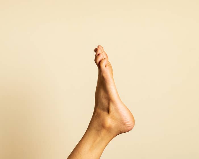 A single foot is photographed against a plain background, with toes pointed upward. No other objects or text are present in the image