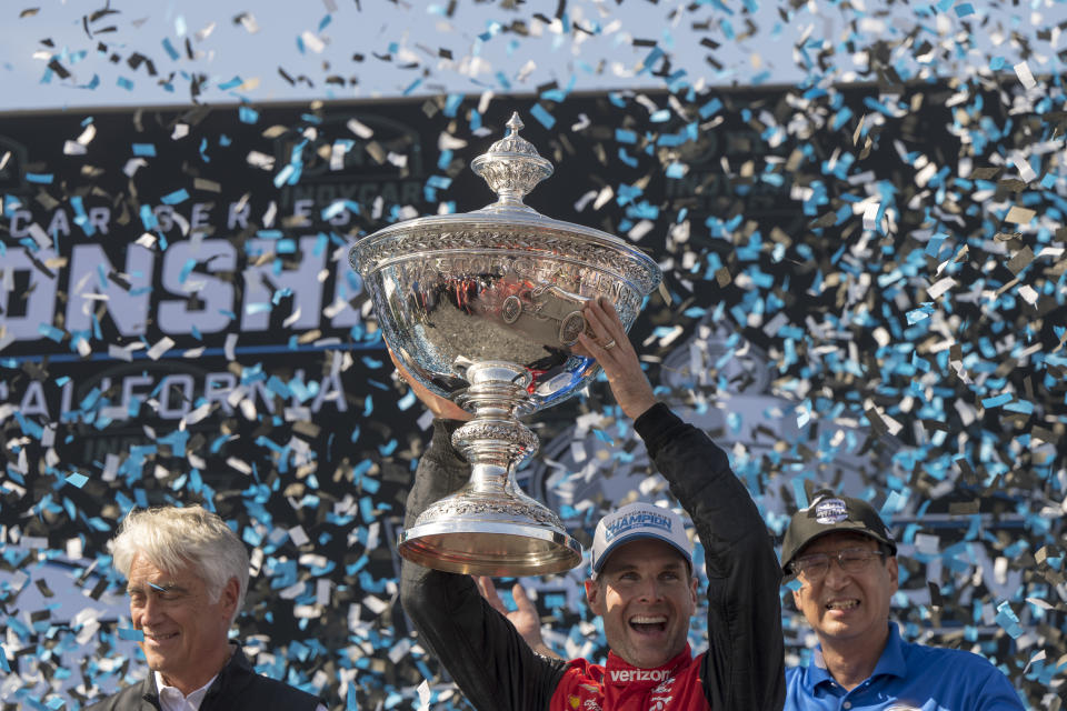 Team Penske driver Will Power, of Australia, holds up the championship trophy after winning the championship after the IndyCar season finale auto race at Laguna Seca Raceway on Sunday, Sept. 11, 2022, Monterey, Calif. (AP Photo/Nic Coury)