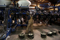 Luke Waddington, the hired hand of farmer Austin Rincker, looks over a planter component as the unit is prepared for the spring planting season in Moweaqua, Illinois, U.S., March 6, 2019. REUTERS/Daniel Acker/Files