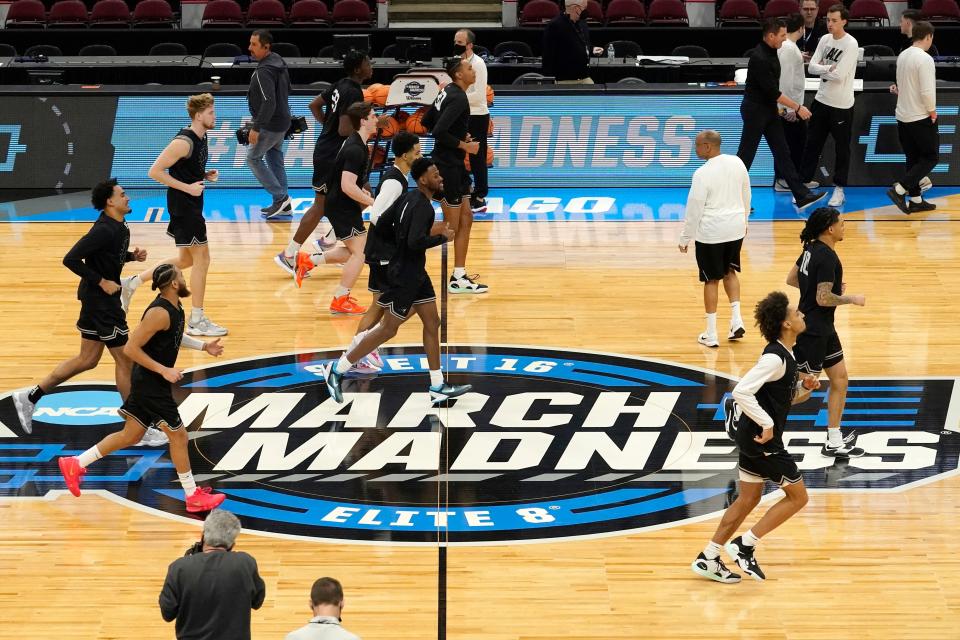 The Providence men's basketball team warms up over the March Madness logo during practice for the NCAA men's college basketball tournament Thursday in Chicago.