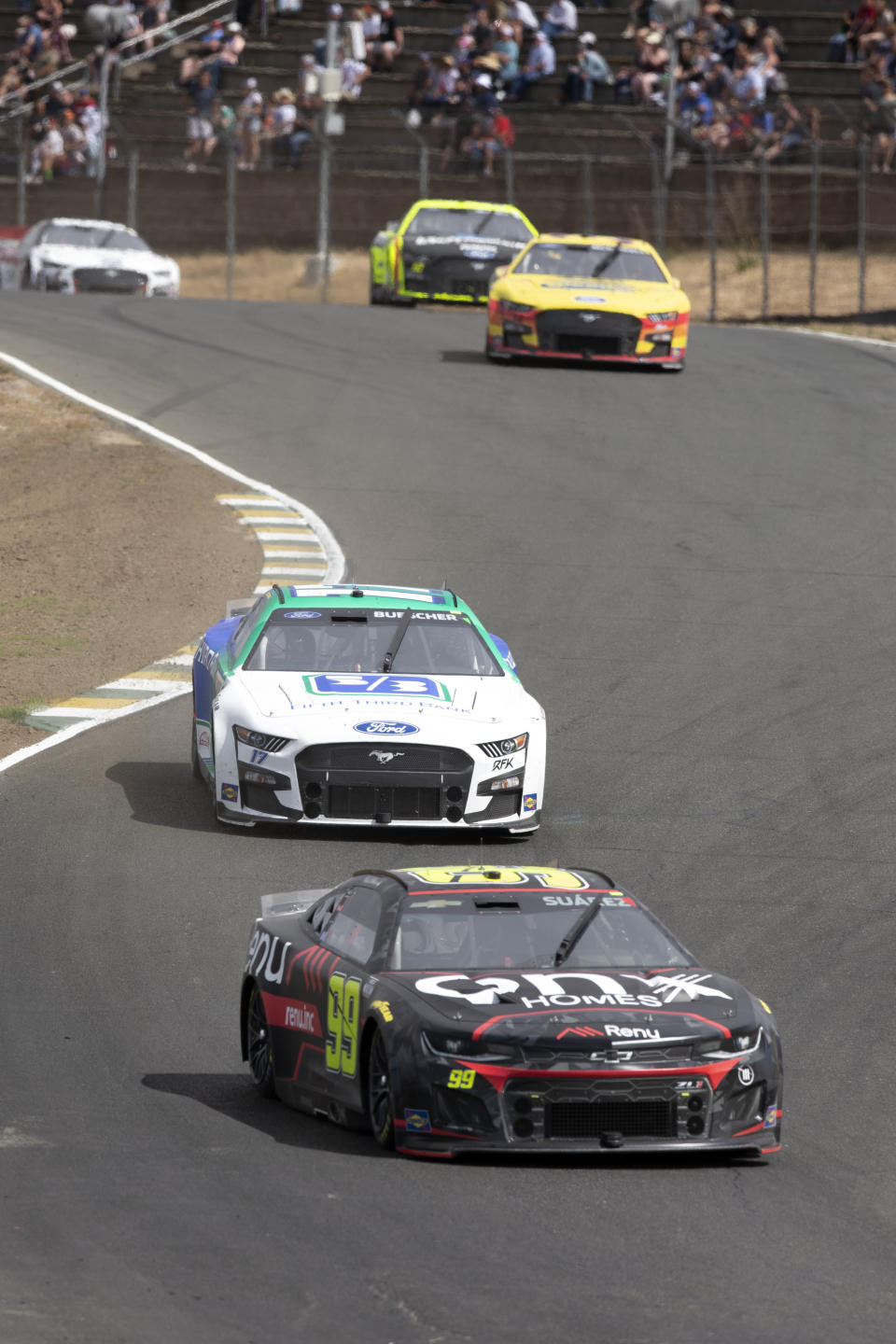 Eventual winner Daniel Suarez (99) leads the pack through Turn 3 during a NASCAR Cup Series auto race, Sunday, June 12, 2022, at Sonoma Raceway in Sonoma, Calif. (AP Photo/D. Ross Cameron)