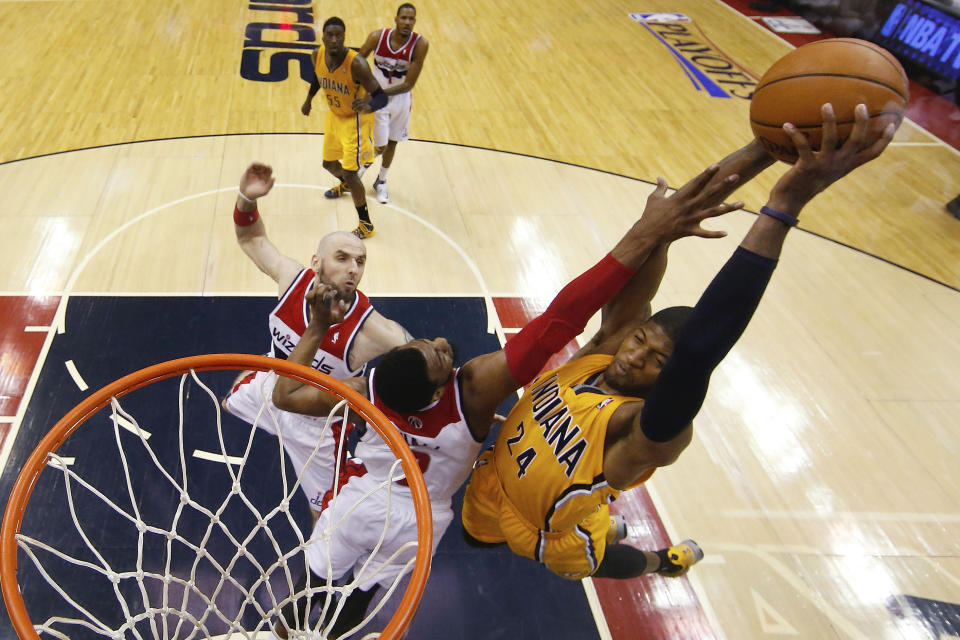 Indiana Pacers forward Paul George (24) shoots over Washington Wizards guard John Wall (2) and Washington Wizards center Marcin Gortat, left, of Poland during the second half of Game 3 of an Eastern Conference semifinal NBA basketball playoff game in Washington, Friday, May 9, 2014. The Pacers won 85-63. (AP Photo/Alex Brandon)