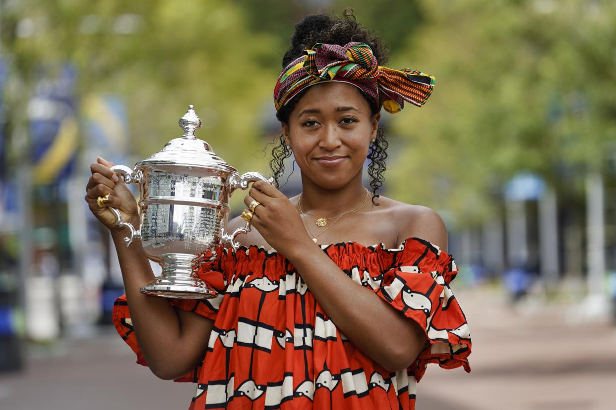 Naomi Osaka, of Japan, holds up the championship trophy while posing for photographs at the Billie Jean King National Tennis Center Sunday, Sept. 13, 2020, in New York.(AP Photo/Frank Franklin II)