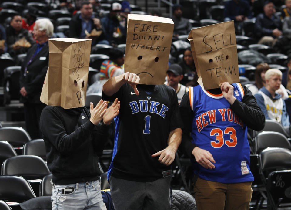 New York Knicks fans wear paper bags on their heads as the Knicks take the court to face the Denver Nuggets in an NBA basketball game Sunday, Dec. 15, 2019, in Denver. (AP Photo/David Zalubowski)