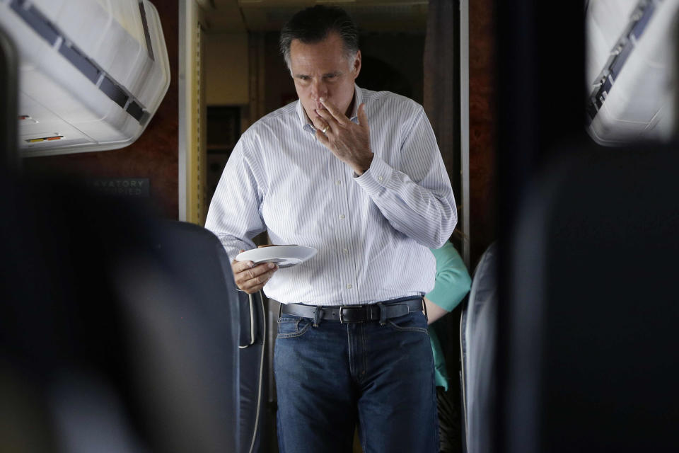 Republican presidential candidate and former Massachusetts Gov. Mitt Romney licks his fingers as he walks back to his seat after making himself a peanut butter and honey sandwich on his campaign plane en route to Las Vegas, Friday, Sept. 21, 2012. (AP Photo/Charles Dharapak)