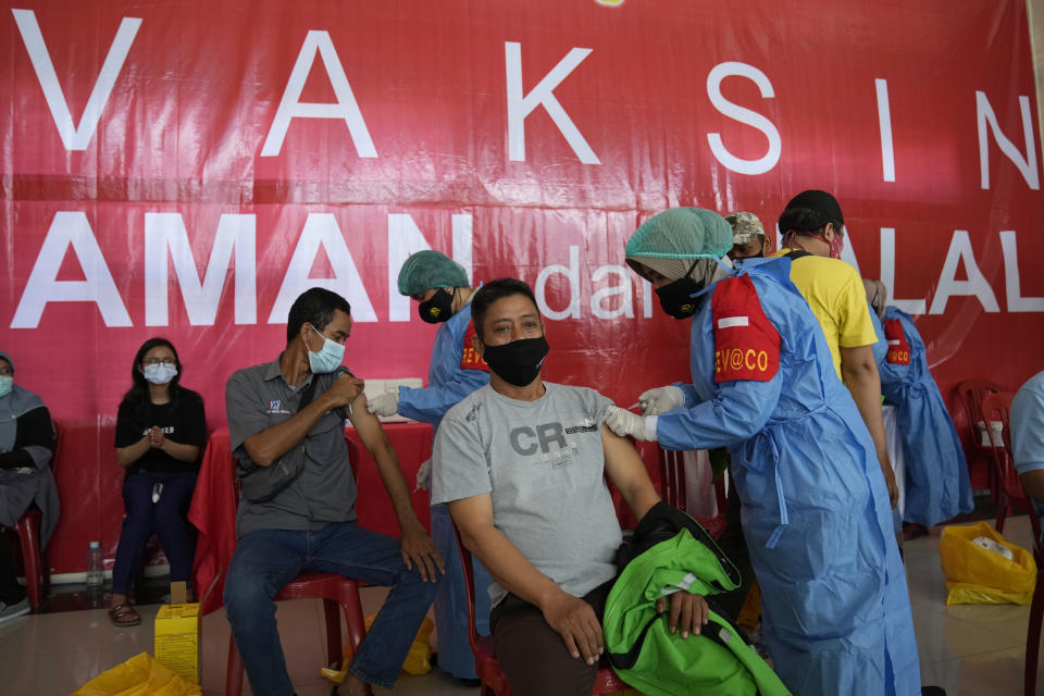 Health workers give shots of Sinovac COVID-19 vaccine during a mass vaccination campaign in Depo, West Java, Indonesia, Friday, June 25, 2021. The world's fourth most populous country is now racing to inoculate as many people amid explosion of COVID-19 cases that have overburdened its health care system, but progress have been slow due to limited global vaccine supply, the unpreparedness of the national health system and vaccine hesitancy. (AP Photo/Dita Alangkara)