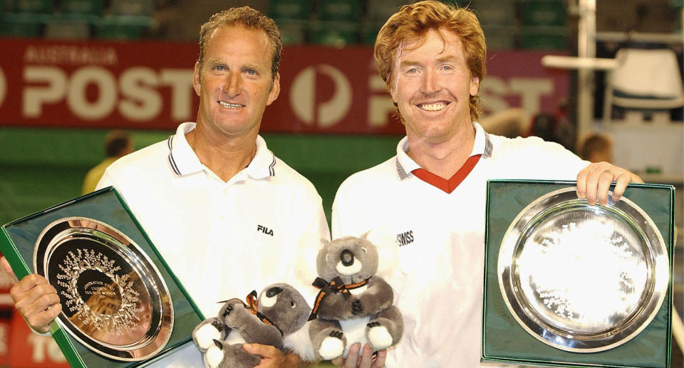 Peter McNamara (left) pictured sharing a victory with doubles partner Mark Woodforde (right) at the Australian Open in Melbourne in 2003. 