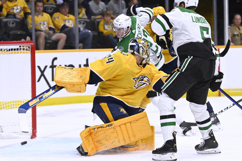 Dallas Stars left wing Mason Marchment, rear, scores a goal against Nashville Predators goaltender Juuse Saros (74) during the first period of an NHL hockey game Thursday, Oct. 13, 2022, in Nashville, Tenn. (AP Photo/Mark Zaleski)