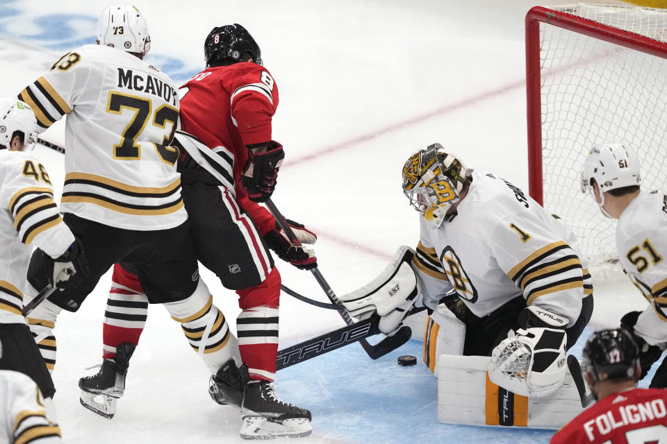 Boston Bruins goaltender Jeremy Swayman makes a pad save on a shot by Chicago Blackhawks' Ryan Donato as Charlie McAvoy also defends during the second period of an NHL hockey game Tuesday, Oct. 24, 2023, in Chicago. (AP Photo/Charles Rex Arbogast)