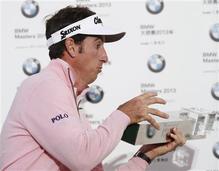 Gonzalo Fernandez-Castano of Spain reacts as he almost drops the trophy after winning the BMW Masters 2013 golf tournament at Lake Malaren Golf Club in Shanghai, October 27, 2013. REUTERS/Aly Song