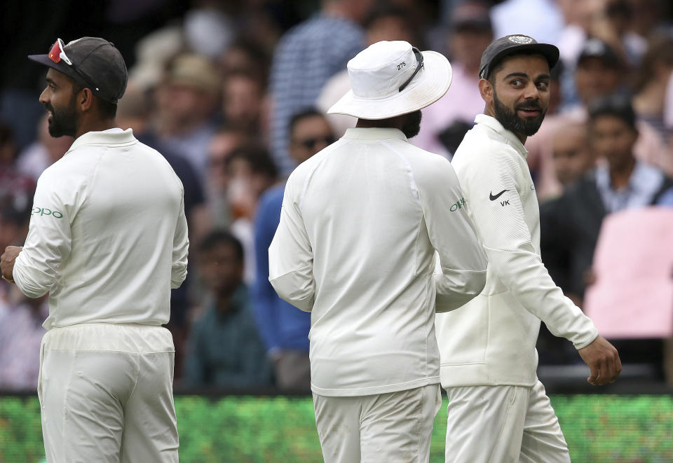 India's Virhat Kohli, right, leads his team off after an early tea break is called due to poor light while playing Australia on day 4 of their cricket test match in Sydney, Sunday, Jan. 6, 2019. (AP Photo/Rick Rycroft)