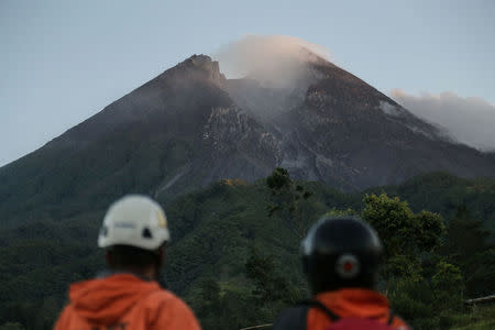 Members of a search and rescue team watch the volcano activity on Mount Merapi after its alert level was increased following a series of minor eruptions in Cangkringan, Sleman, Yogyakarta, Indonesia May 22, 2018 in this photo taken by Antara Foto. Antara Foto/Hendra Nurdiyansyah/via REUTERS